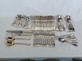 a lot of silver spoons and forks on a table