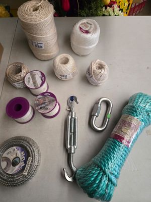 une table sur laquelle se trouvent un tas de pelotes de laine, des ciseaux et un crochet