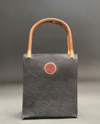 a black leather bag with a wooden handle and a wooden handle