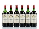 four bottles of wine are lined up on a white surface