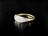 a close up of a gold and diamond ring on a black surface