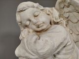 a statue of an angel holding a heart in his hands