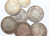 a bunch of silver coins sitting on top of a white surface