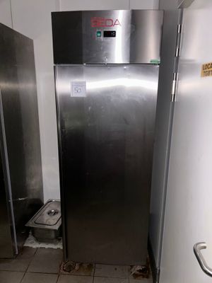 a stainless steel refrigerator in the corner of a room