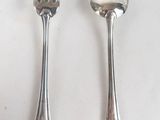 two spoons and a fork on a white table