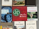 Plusieurs livres sont disposés sur une table devant un fond gris.