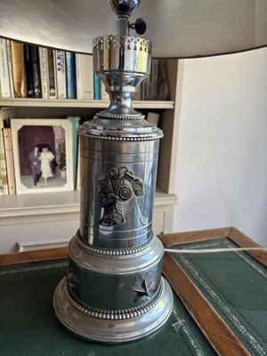 une horloge en argent posée sur une table verte
