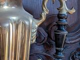 a gold vase sitting on top of a wooden table