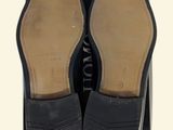 the shoe box is holding two pairs of black shoes