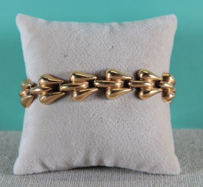un gros plan d'un bracelet en or posé sur un oreiller