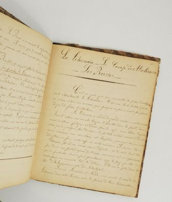 an old open book with writing on it sitting on top of a table