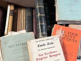 several books are stacked on top of each other in a box
