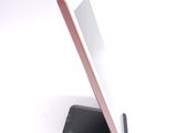 a tablet computer sitting on a stand on a white surface