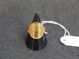 une pièce d'or posée sur un cône, avec une étiquette de prix dessus