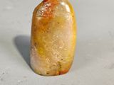an image of a yellow stone sitting on top of a white surface