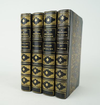 un lot de quatre livres noirs et dorés empilés les uns sur les autres