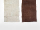 trois morceaux de tissu marron, blanc et marron accrochés à un mur