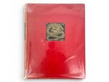 un livre rouge sur lequel figure l'image d'un dragon