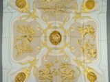 a white and gold square scarf with a design of lions and lions