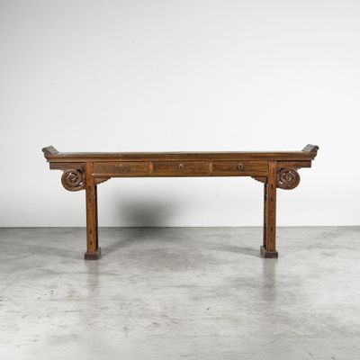 a wooden table with two drawers on top of it in a room