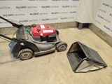 a lawn mower that is sitting on the ground next to a trash can