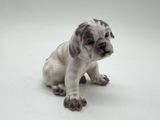 a figurine of a dog sitting on a white surface