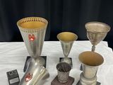de nombreux vases en argent de styles variés posés sur une table