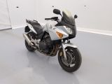 a white motorcycle parked in a room with a white wall