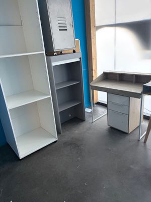 une photo d'une pièce avec un bureau et des étagères