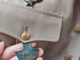 a person in a uniform holding a small broocher