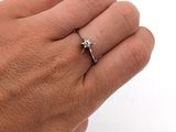 la main d'une personne tenant une bague sertie d'un diamant