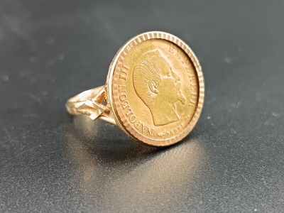 an image of a gold coin ring with a face on it
