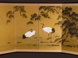 an image of two cranes standing in front of a tree
