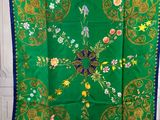 a green and blue scarf with a floral design on it
