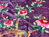 an image of a purple quilt with a bird and flowers on it