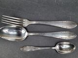 three spoons and two spoons sitting on a table