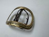 an antique brass buckle on a white surface with a white background
