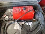 a red box with wires in it on the floor