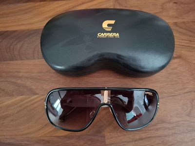 un gros plan sur une paire de lunettes de soleil posée sur un parquet