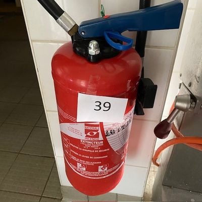 un extincteur rouge fixé au mur