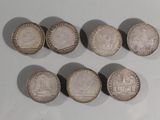 six pièces de monnaie britanniques différentes posées sur une surface blanche