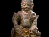 an image of a statue of a person sitting on a rock