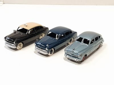 four toy cars that are lined up on a white surface