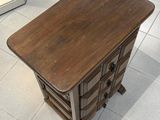 une petite table avec un tiroir, placée au milieu d'une pièce