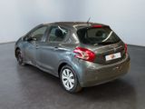 the back of a silver car in a room with a black floor