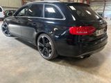the rear end of a black car parked in a garage