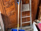 a ladder that is leaning against the wall next to a blue bin