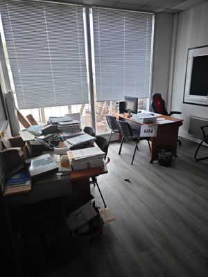 une photo d'un bureau encombré, avec beaucoup de désordre sur le bureau