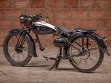 a old motorcycle that is parked in front of a brick wall