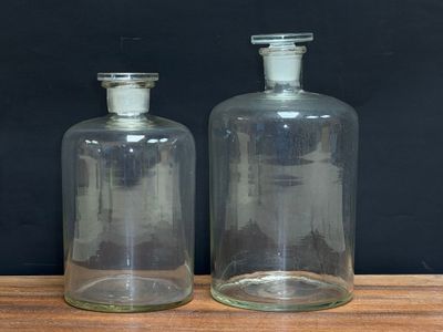 two empty glass bottles sitting on a wooden table